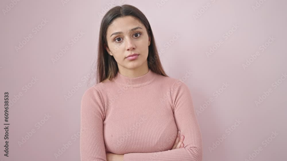 Young beautiful hispanic woman smiling with thumbs up over isolated pink background