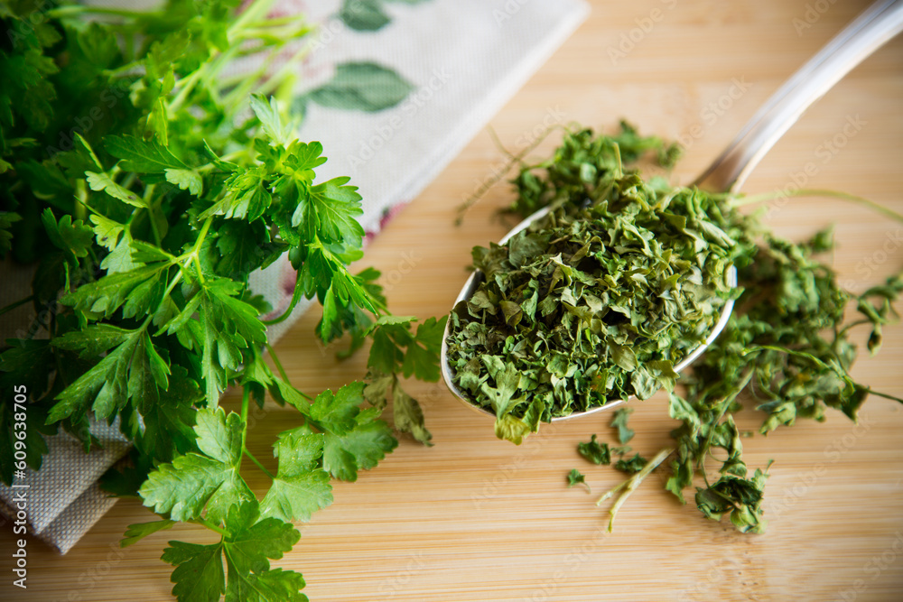 dried parsley in a spoon next to fresh herbs. dried parsley in a spoon next to fresh herbs.