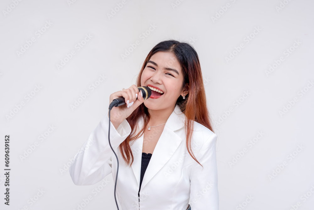 A cheerful young woman mouth wide open into a microphone while looking at the camera. Isolated on a white background. A cheerful young woman mouth wide open into a microphone while looking at the camera. Isolated on a white background.