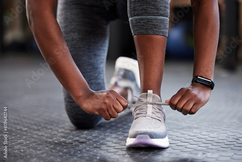 Hands, shoelaces or shoes at gym with woman, fitness or starting workout, wellness or training. Ready, footwear closeup or girl with sneakers for exercise, performance or health motivation in studio