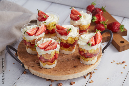 Photos Glasses with strawberry trifle desserts on wooden table