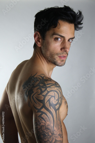 Male shirtless model with perfect body posing over white background. Close-up. Studio shot.