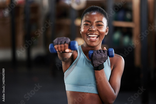 Portrait of boxer, dumbbell or happy black woman training, exercise or workout for a strong punch or power. Smile, face or African girl boxing with dumbbells, weights or exercising in fitness gym