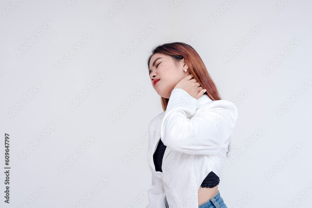 A pained young woman with tilted head holding her stiffed neck in pain. Isolated on a white background. A pained young woman with tilted head holding her stiffed neck in pain. Isolated on a white background.