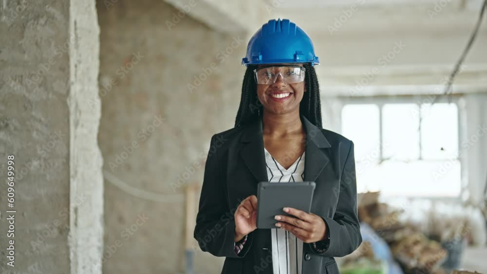 African american woman architect smiling confident using touchpad at construction site