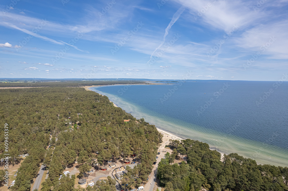 Obraz premium Aerial view of a beach and sea. Beautiful sea, maritime landscape, seascape. Forest near the beach. Sunny summer day. Resort and recreational area.