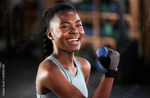 Gym portrait, dumbbell or happy black woman training, exercise or workout for powerful arms or muscles. Smile, face or African girl lifting dumbbells, weights or exercising biceps in fitness studio