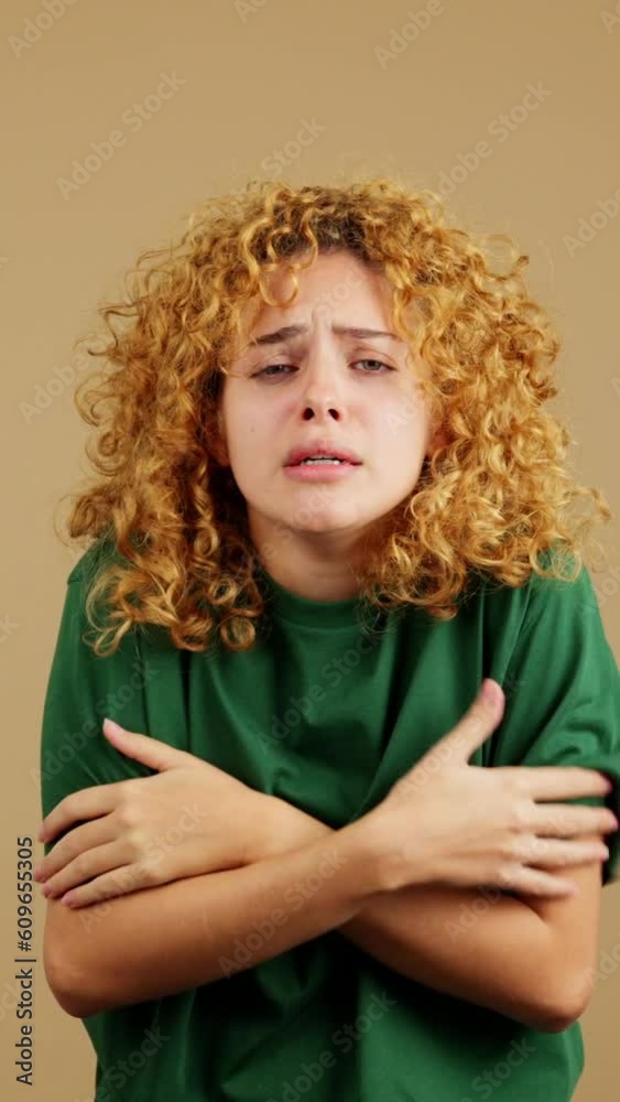 Woman who is very cold on brown background Woman who is very cold on brown background