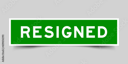 Green color square label sticker with word resigned on gray background