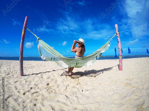bela mulher relaxando em rede em praia paraíso tropical 