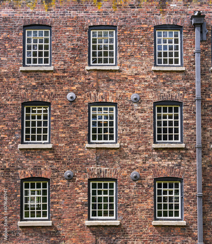 Exterior of restored cotton spinning and weaving mill in north of England with focus on windows