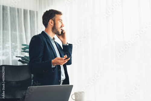 фотографія Hardworking businessman stand confidently in modern office making persuasive sales call to client