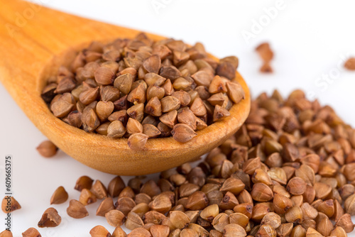 Uncooked buckwheat on wooden spoon