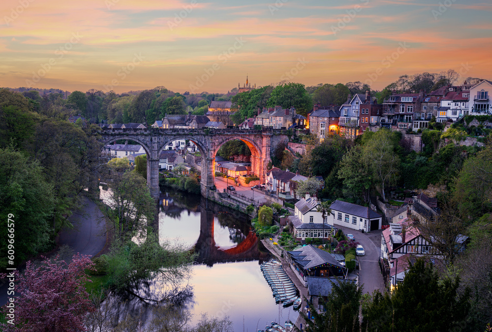 Stone viaduct over River Nidd at Knaresborough with rowing boats by riverbank