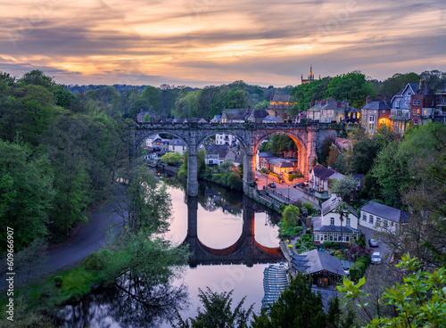 Stone viaduct over River Nidd at Knaresborough with rowing boats by riverbank photo