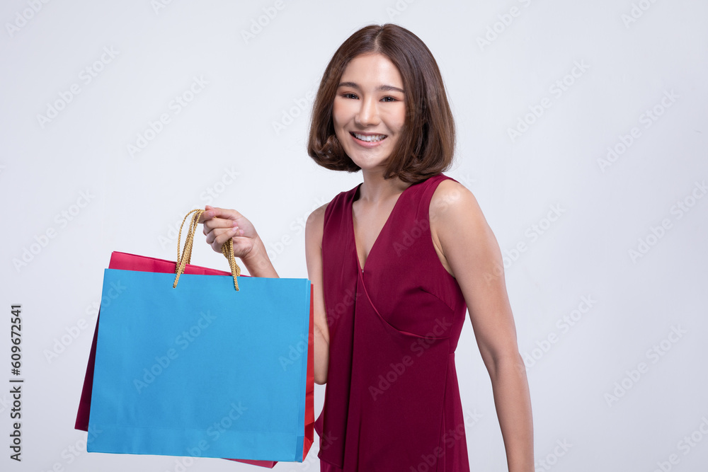 Shopping Asian woman with short hairs smile wearing red dress Holding Shopping bags,Cheerful and Happiness enjoy shopping in black friday sale,Isolated on gray background Shopping Asian woman with short hairs smile wearing red dress Holding Shopping bags,Cheerful and Happiness enjoy shopping in black friday sale,Isolated on gray background
