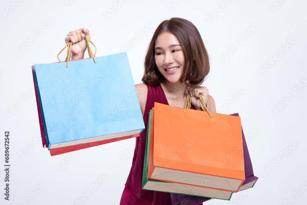 Shopping Asian woman with short hairs smile wearing red dress Holding Shopping bags,Cheerful and Happiness enjoy shopping in black friday sale,Isolated on gray background Shopping Asian woman with short hairs smile wearing red dress Holding Shopping bags,Cheerful and Happiness enjoy shopping in black friday sale,Isolated on gray background