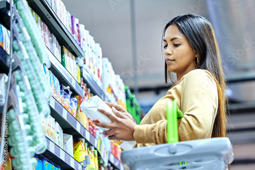 Canvastavla Grocery, shopping and choice with woman in supermarket for food, retail or label reading