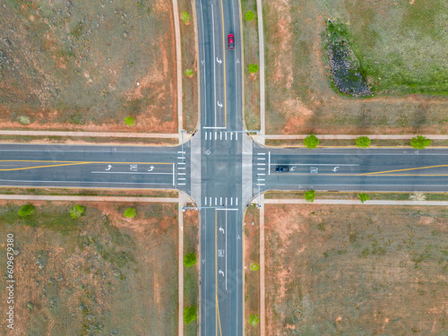 Top down view of intersection of road with cars at stoplights from aerial drone photo