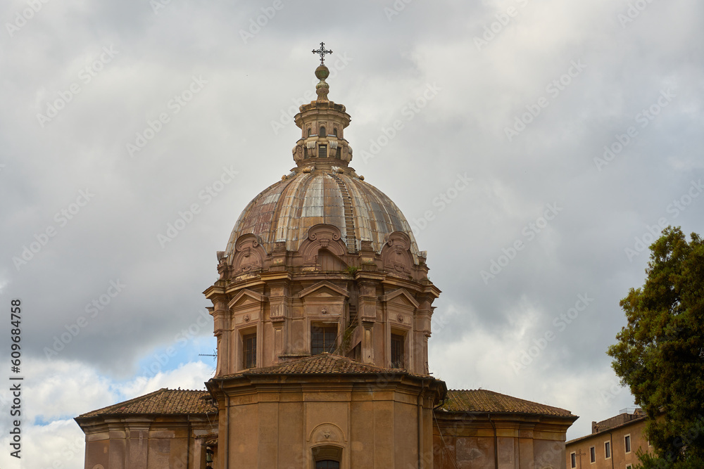 The dome of an ancient Roman building against the background of a cloudy sky.