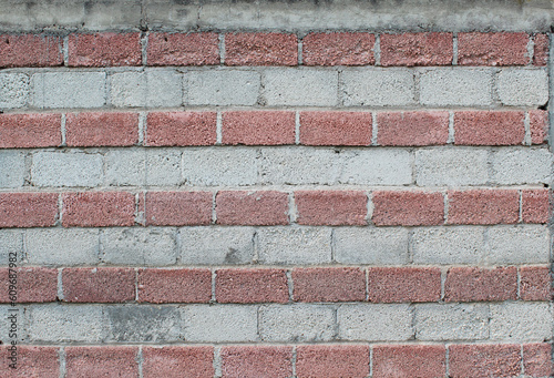 Pared con hileras de ladrillo rojo y gris.  