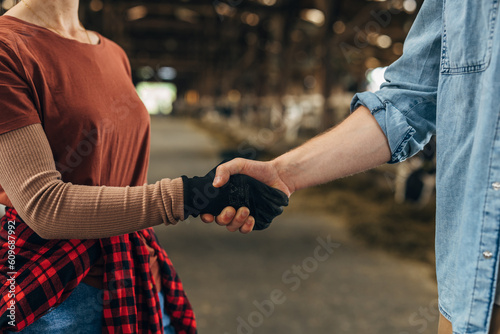 Handshake between man and woman in a stable.