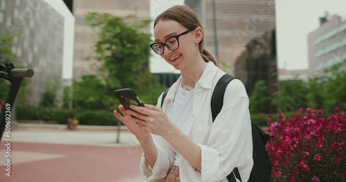 A young woman chats on a smartphone with her business partners. A business woman with a smartphone at the office.