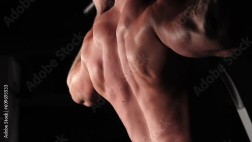 muscular athlete does an exercise to pump the sphene muscles photo
