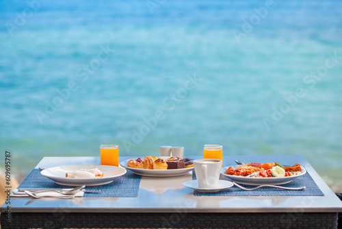 Fotografie Delicious breakfast on coast, surrounded by the stunning views of the beach