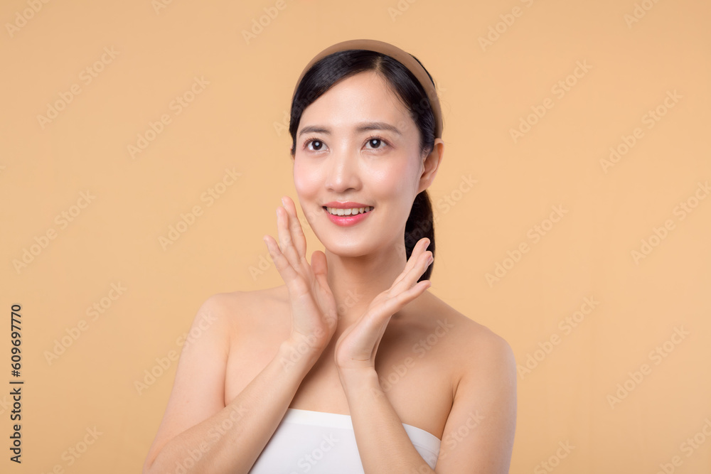 Beautiful girl asian model touching fresh glowing hydrated facial skin on beige background closeup. Beauty face young woman with natural makeup and healthy skin portrait. Skin care concept Beautiful girl asian model touching fresh glowing hydrated facial skin on beige background closeup. Beauty face young woman with natural makeup and healthy skin portrait. Skin care concept