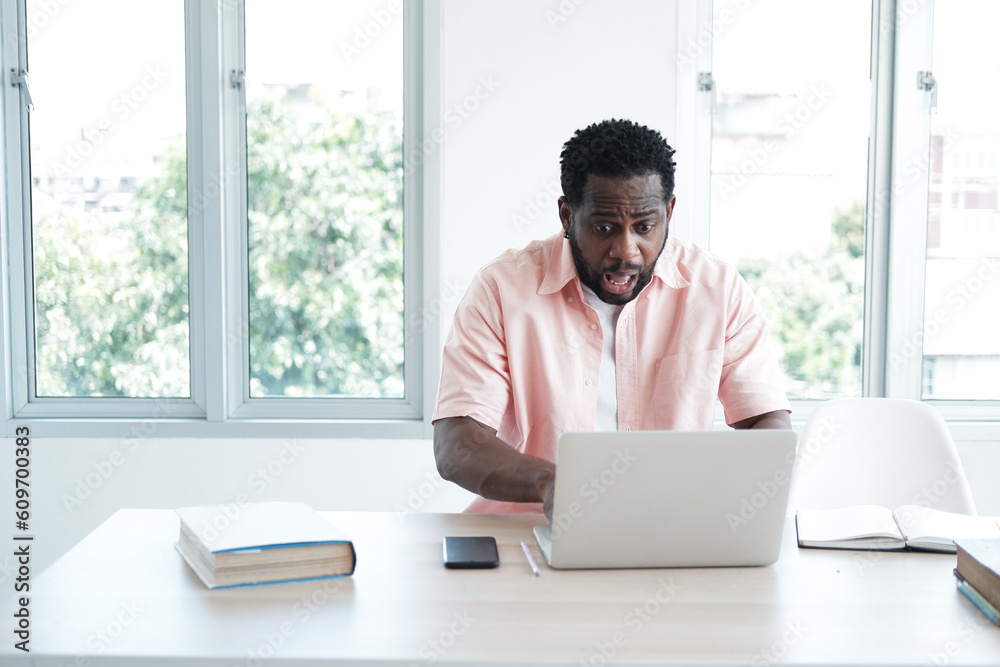 Young African Businessman is online working with internet on laptop at office. He is serious and headache for have work problems in project. Business and Technology for lifestyle Concept. Young African Businessman is online working with internet on laptop at office. He is serious and headache for have work problems in project. Business and Technology for lifestyle Concept.