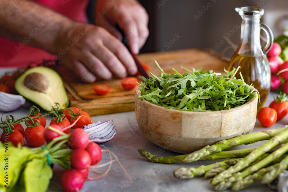 Man cooking healthy vegetarian food while standing at home in the kitchen Man cooking healthy vegetarian food while standing at home in the kitchen