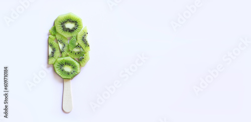 Kiwi slices laid out in the form of ice cream, top view. Ice cream on a stick, banner with a light background. Three ice creams. Summer banner with kiwi, copy space