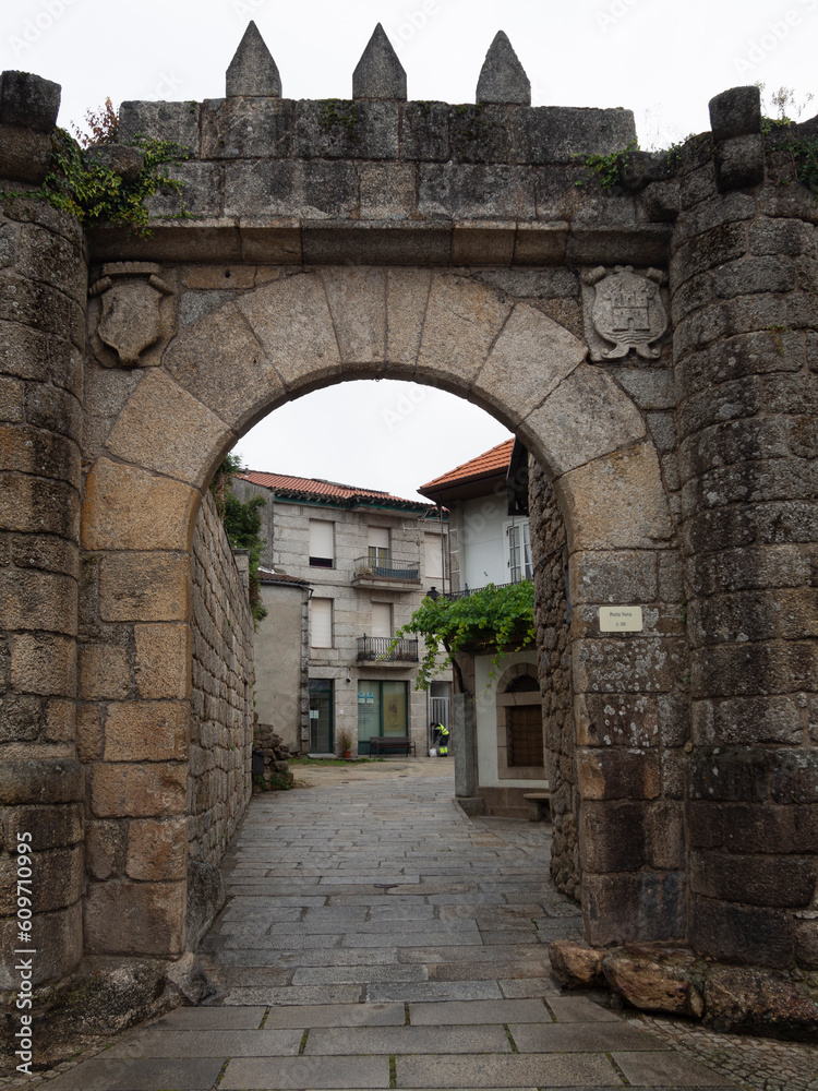 Arch-shaped medieval gate in the wall of Ribadavia, Orense, with shields, in Spain, summer of 2021
