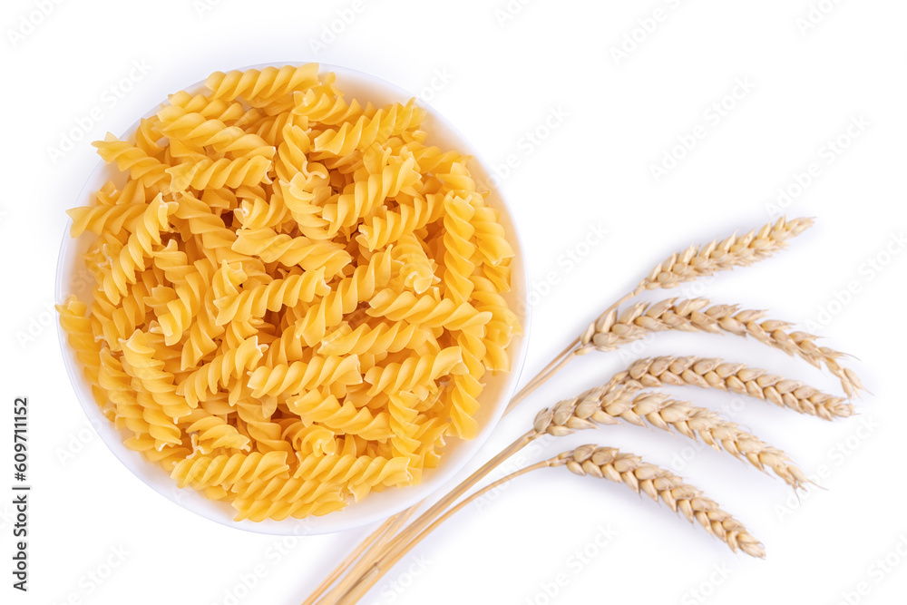 Fototapeta premium Pasta and wheat spikelets isolated on white background. Raw pasta fusilli, ingredient for cook, traditonal italian cuisine. Flat lay, top view