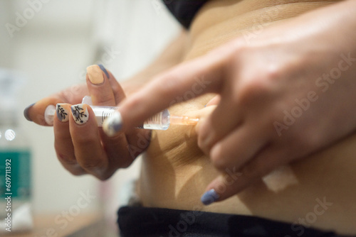 woman injecting herself with syringe during IVF fertility treatment