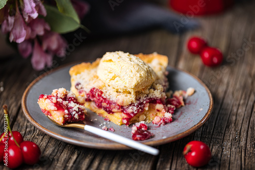 Tart with sour cherry creme, creme patisserie and crumbs, served with vanilla ice cream. Rustic and moody atmosphere and decoration. 