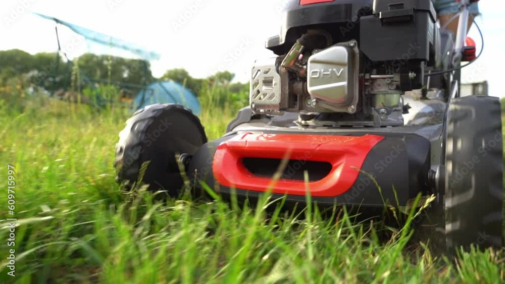 Lawn mover on green grass in modern garden. Machine for cutting lawns. Lawn mover on green grass in modern garden. Machine for cutting lawns.