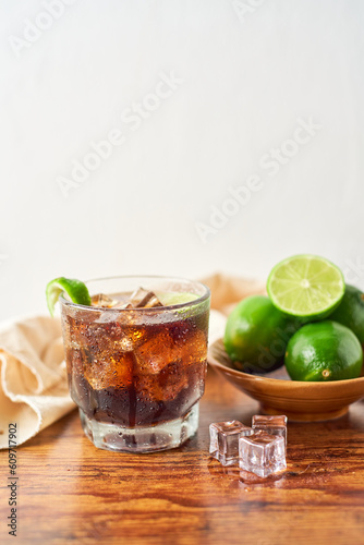 Glass of tasty Cuba Libre cocktail on table from caribbean, focus selective