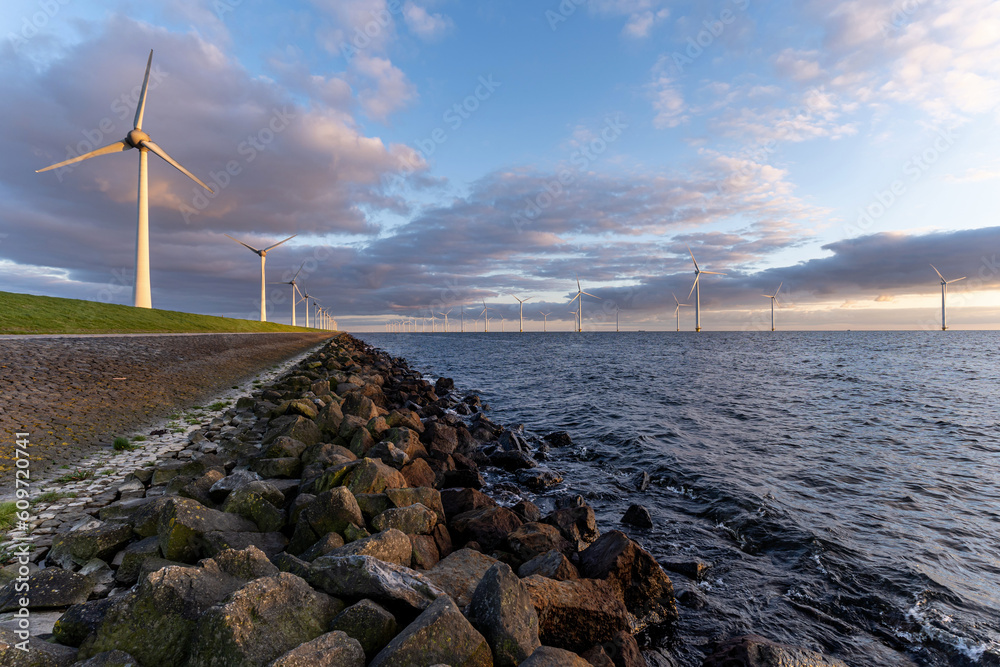 onshore and offshore wind farm at sunset