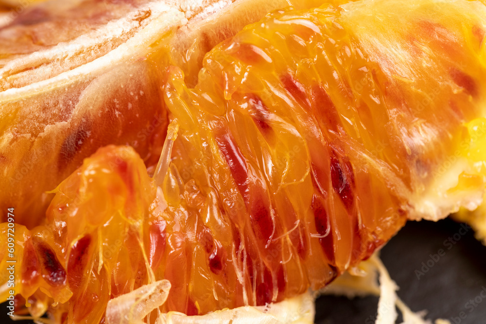 the red-orange flesh of an orange sliced in close-up the red-orange flesh of an orange sliced in close-up