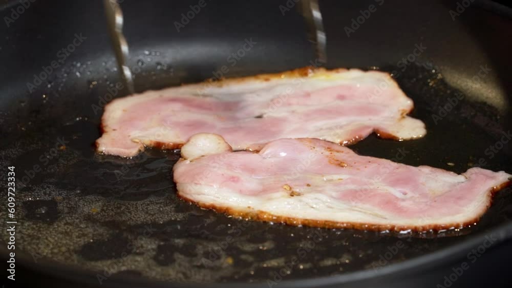 Frying Bacon Slices in a Pan. Crispy Pieces of Delicious Red Thin Smokey Bacon Fried in a Hot Skillet. Traditional Breakfast. Smoked Bacon Rasher or Strip Being Cooked. Grill. Fat High Calorie Food. Frying Bacon Slices in a Pan. Crispy Pieces of Delicious Red Thin Smokey Bacon Fried in a Hot Skillet. Traditional Breakfast. Smoked Bacon Rasher or Strip Being Cooked. Grill. Fat High Calorie Food.