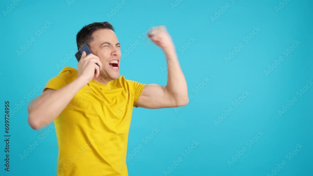 Man celebrating raising the fist while talking on the phone Man celebrating raising the fist while talking on the phone