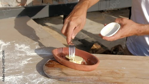 Butter is melt in a hot clay pot and three eggs are cracked in it