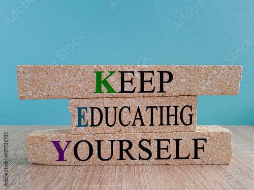 Keep educating yourself symbol. Brick blocks with words 'KEY, keep educating yourself'. Beautiful blue background, copy space. Business, educational and KEY, keep educating yourself concept. photo