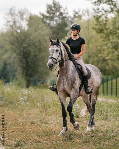 Young woman and her beautiful red horse during calm trail ride. Ecotourism and animal care concepts.