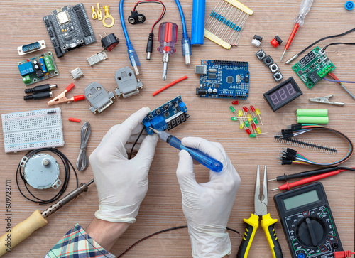Εκτύπωση καμβά An engineer's hands are assembling a breadboard from an Arduino microcontroller, surrounded by electronics tuning tools