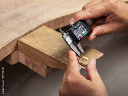 Jeweler measuring a metal ring with a caliper