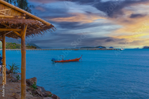 Colourful Skies Sunset over Rawai Beach in Phuket island Thailand. Lovely turquoise blue waters, lush green mountains colourful skies and beautiful views the pier and longtail boats and islands  © Elias Bitar