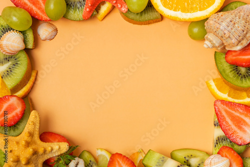 Frame made from citrus fruits and strawberries, seashells with copy space flat lay, top view © Alina